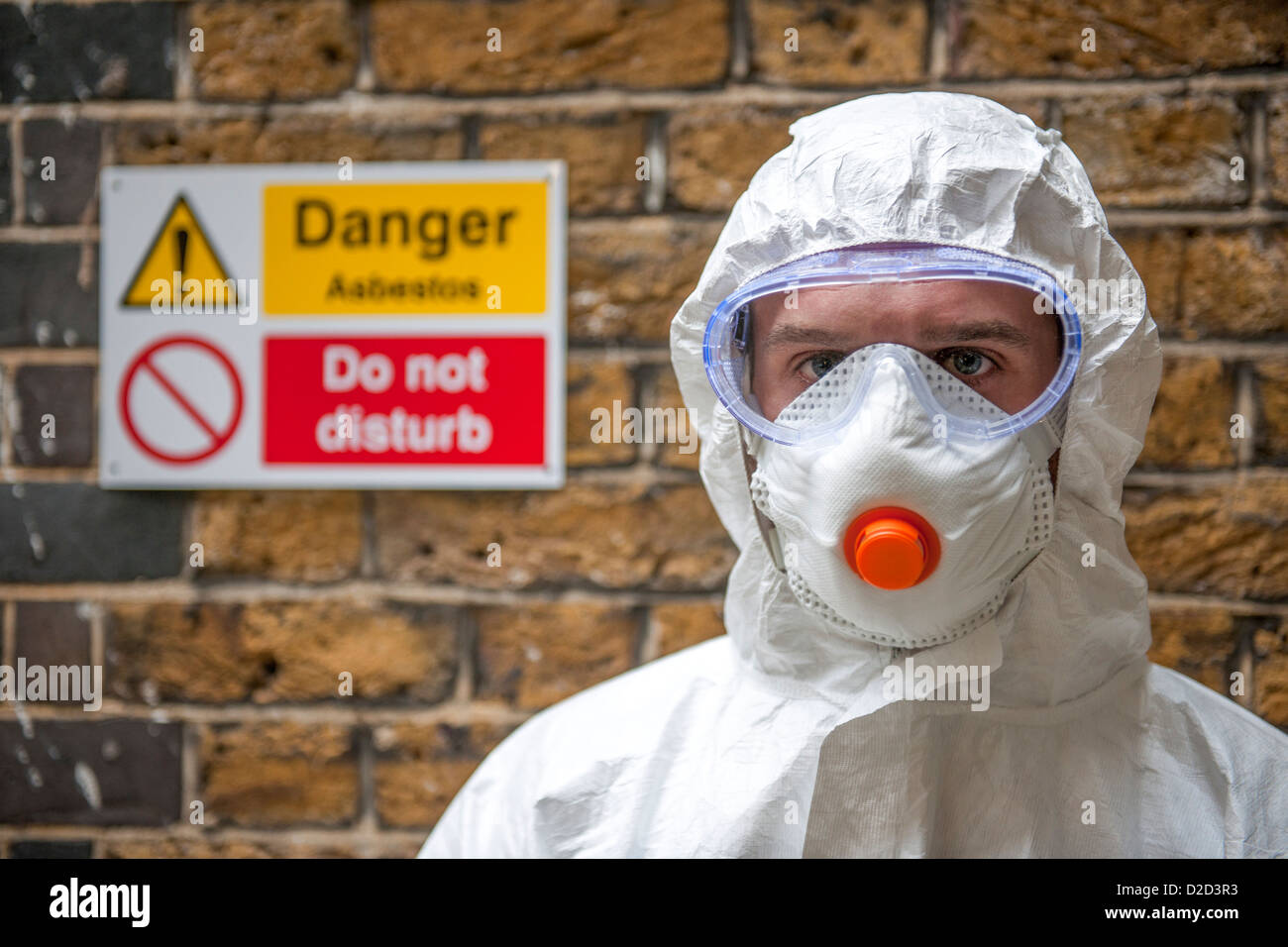 MODEL RELEASED Asbestos protection Worker wearing protective clothing a face mask and safety goggles Stock Photo