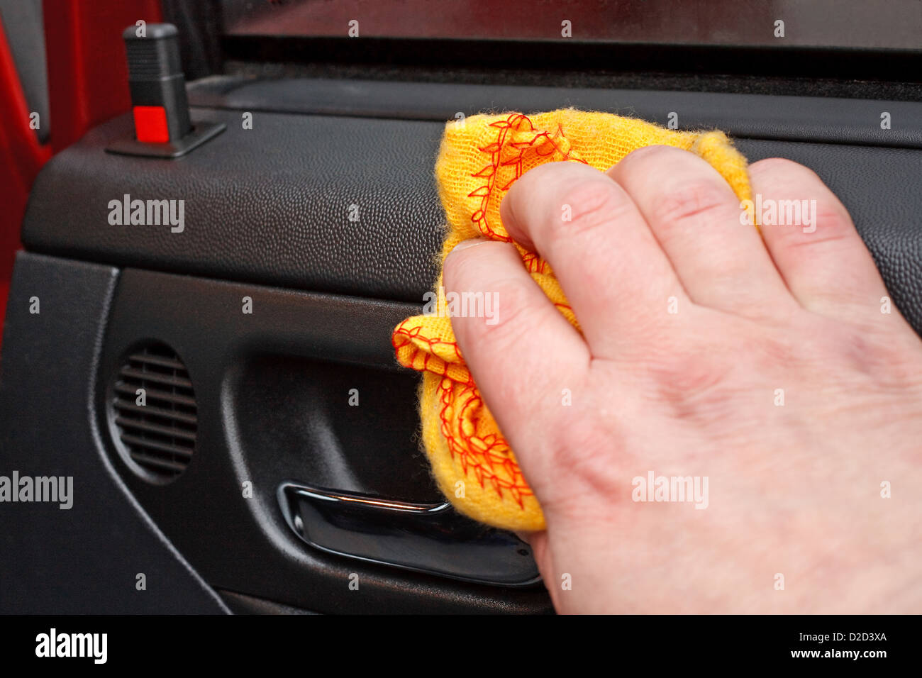 Cleaning the car door interior with yellow polishing cloth Stock Photo