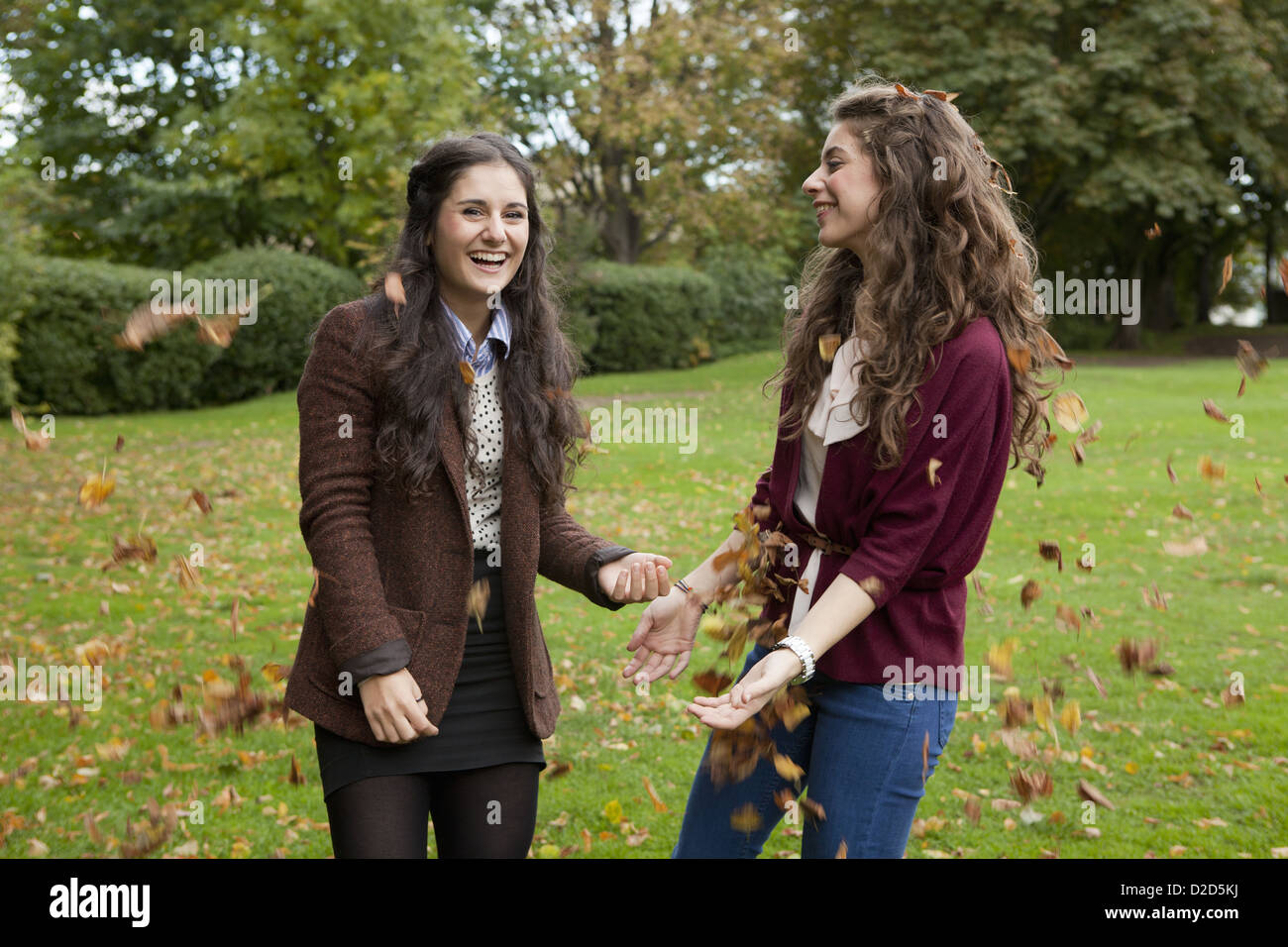 Smiling girls playing in autumn leaves Stock Photo - Alamy