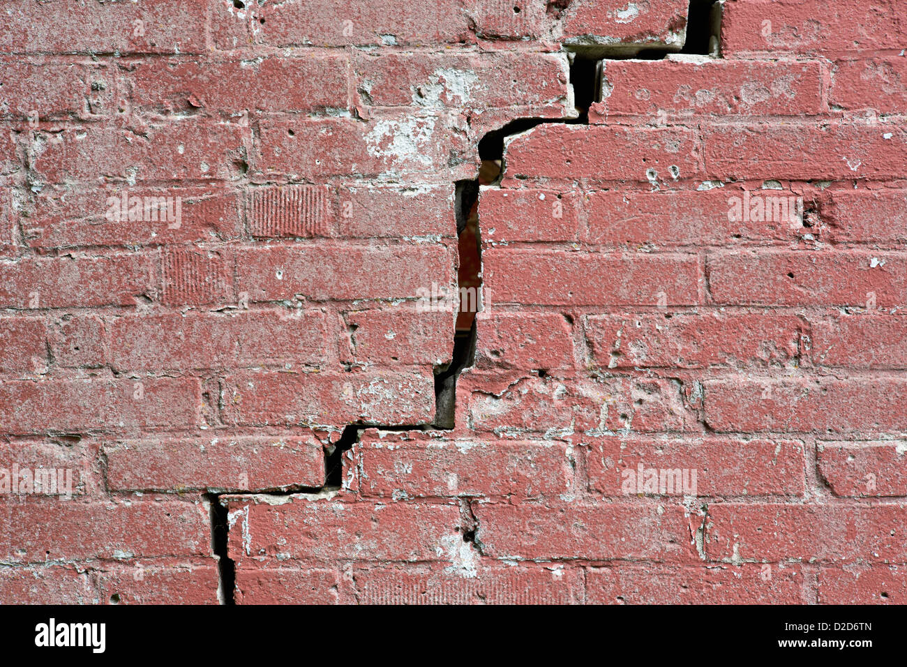 Close-up of a crack running through a red brick wall Stock Photo