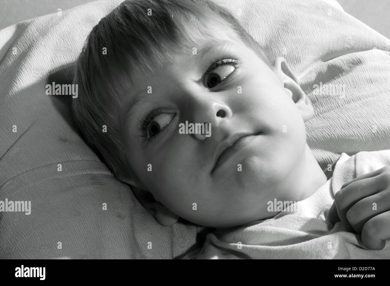 boy lying on a bed, black and white Stock Photo