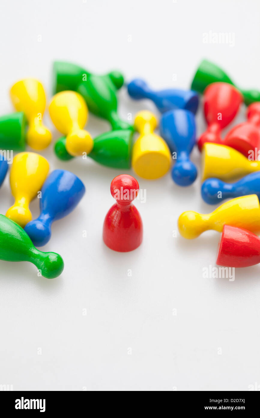 Upright game piece amongst many knocked down game pieces Stock Photo