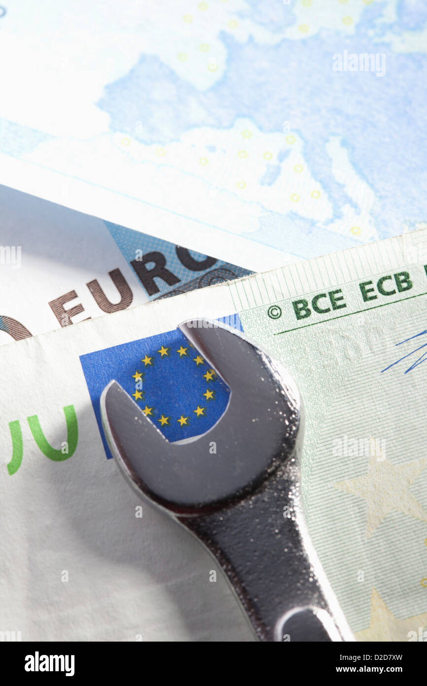 Spanner turning the stars of the EU flag on a Euro bank note Stock Photo