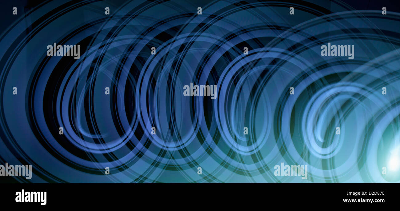Light trails creating an abstract blue spiral pattern on a black ...