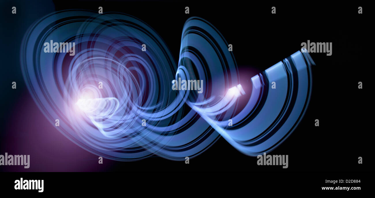 Light trails creating an abstract blue spiral pattern on a black background Stock Photo