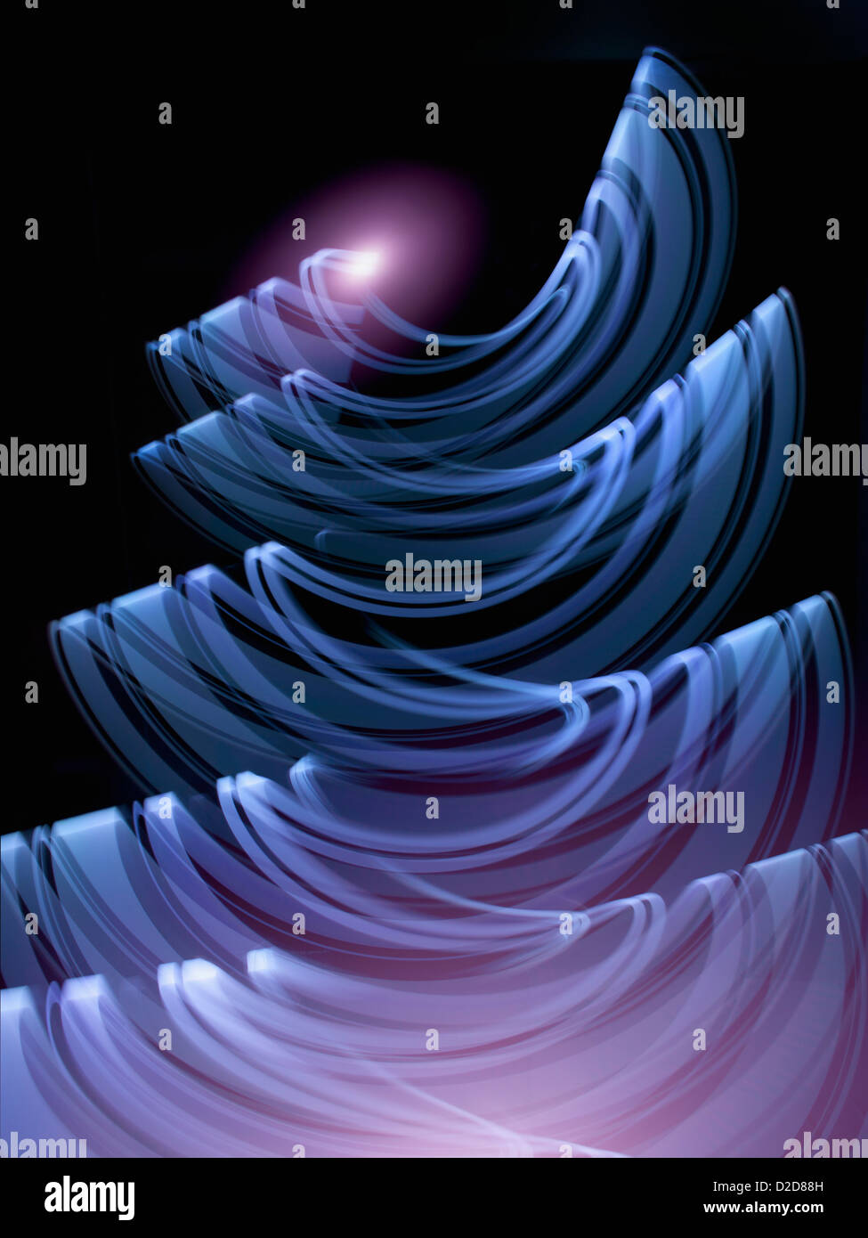 Violet, blue light trails creating an abstract wave pattern on black background Stock Photo