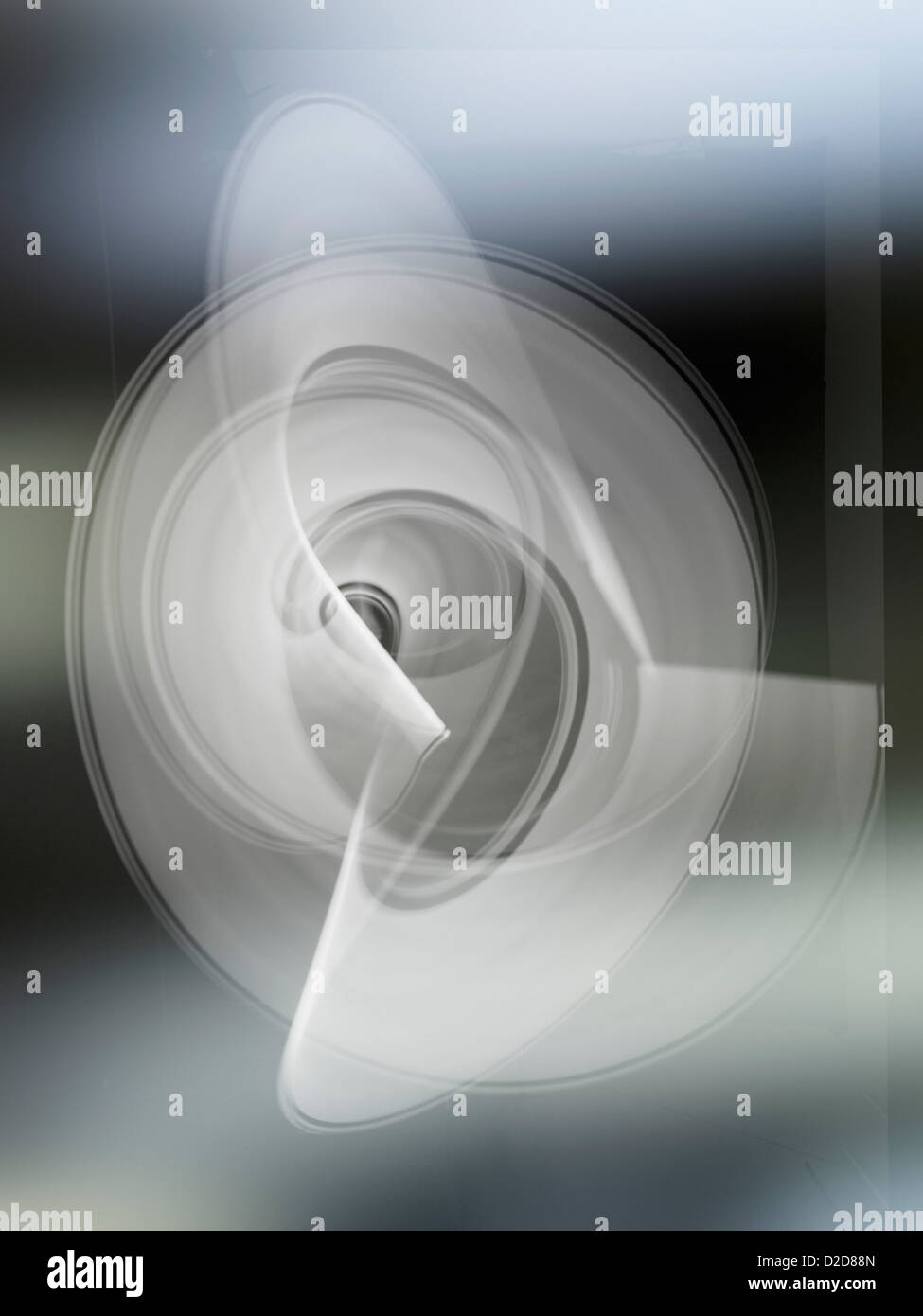 Light trails creating an abstract white swirling circle pattern on a gray background Stock Photo