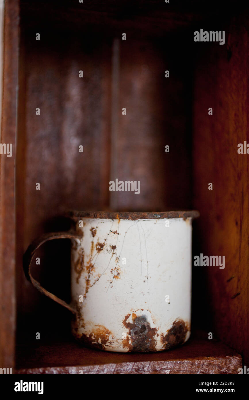 A metal cup on a wooden shelf Stock Photo