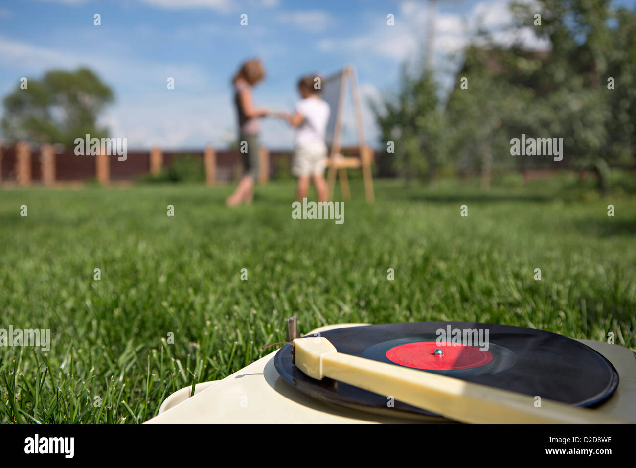 An old-fashioned record player on a lawn, children in background Stock Photo