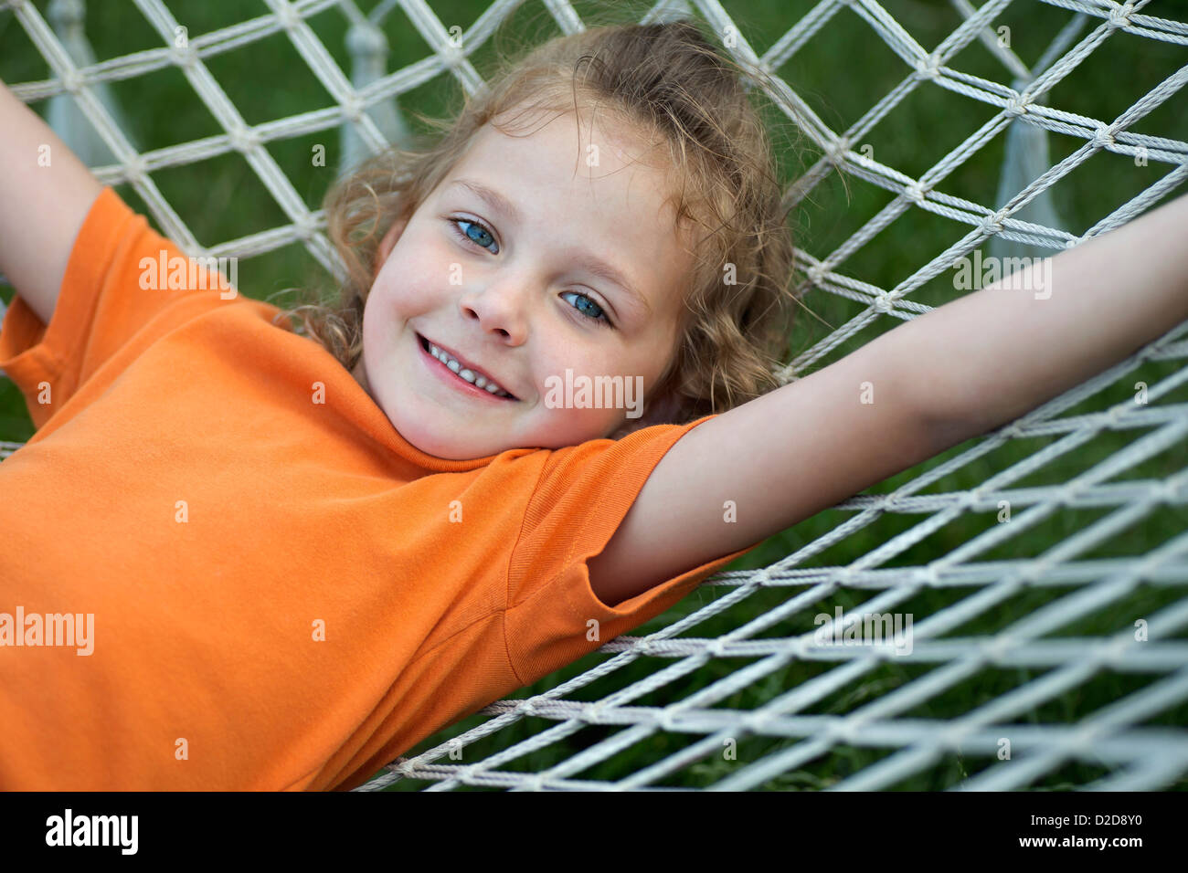 A young cheerful girl lying on a hammock Stock Photo