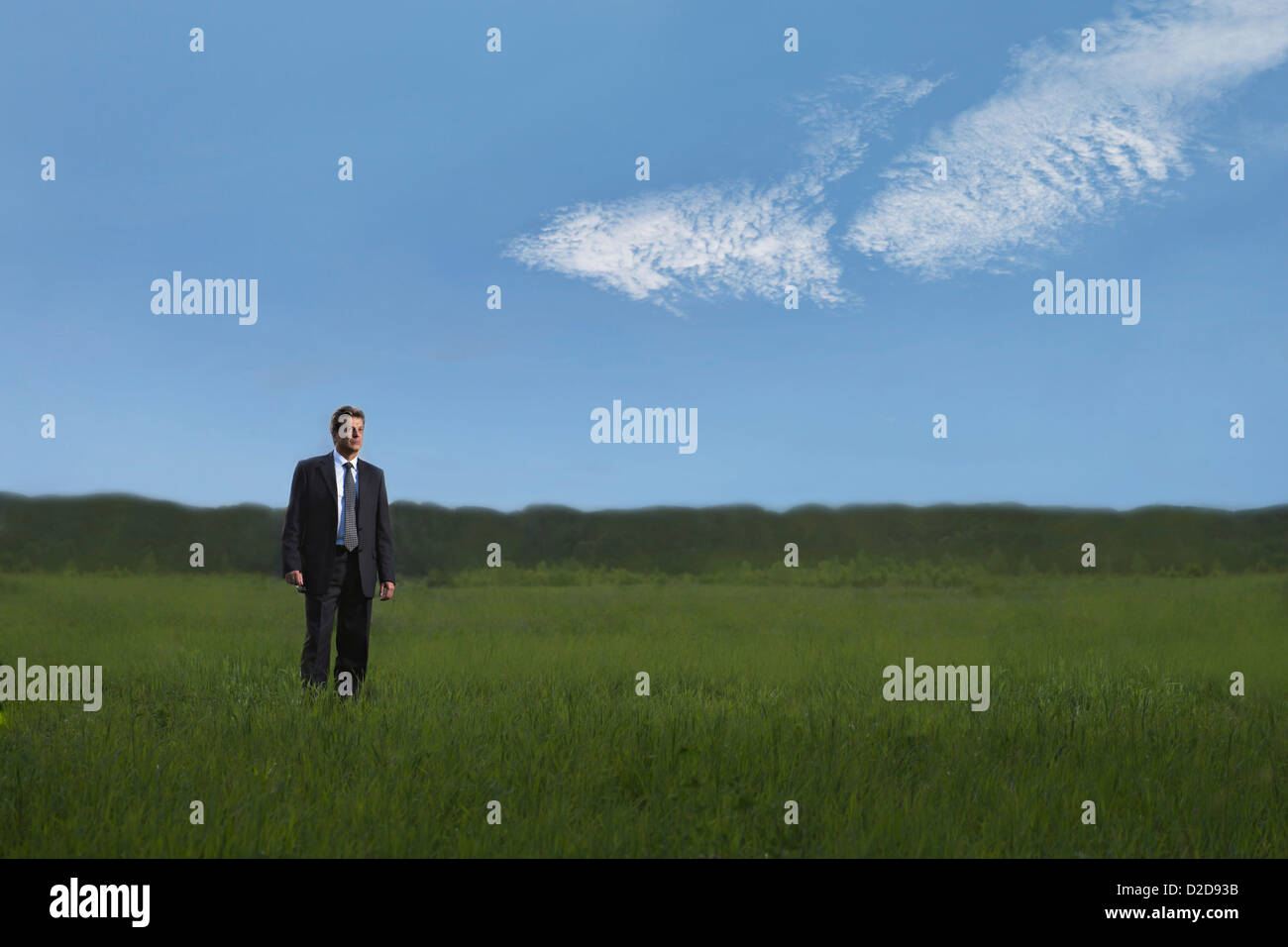 A businessman walking through a field in a remote location Stock Photo