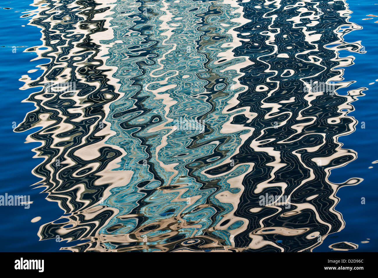 A highrise building reflects patterns onto smooth water. Stock Photo