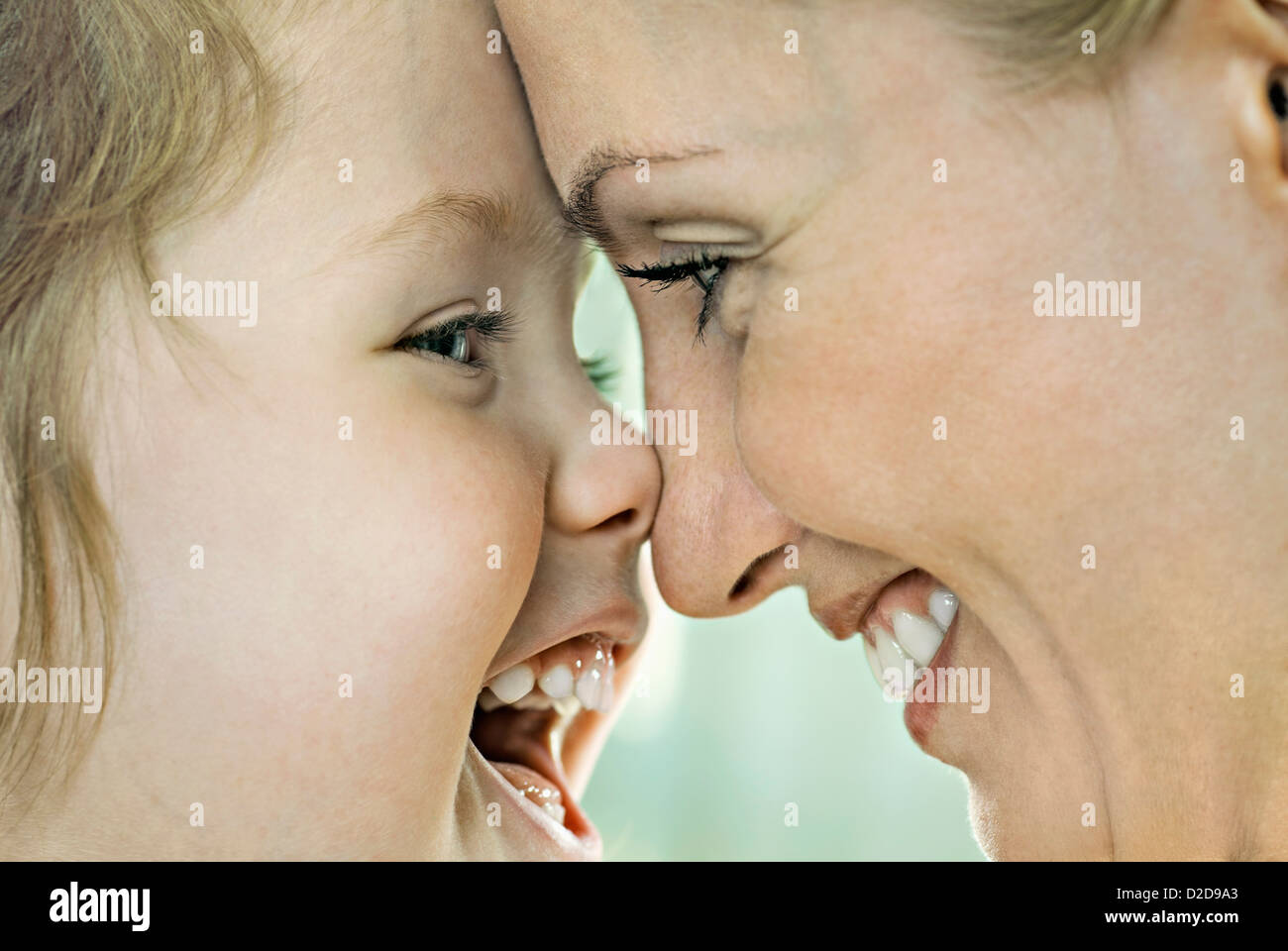 A laughing girl touching noses with her smiling mother, close-up Stock Photo