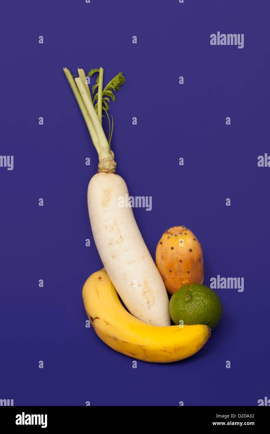 A turnip, banana, lime and prickly pear arranged into an abstract shape Stock Photo