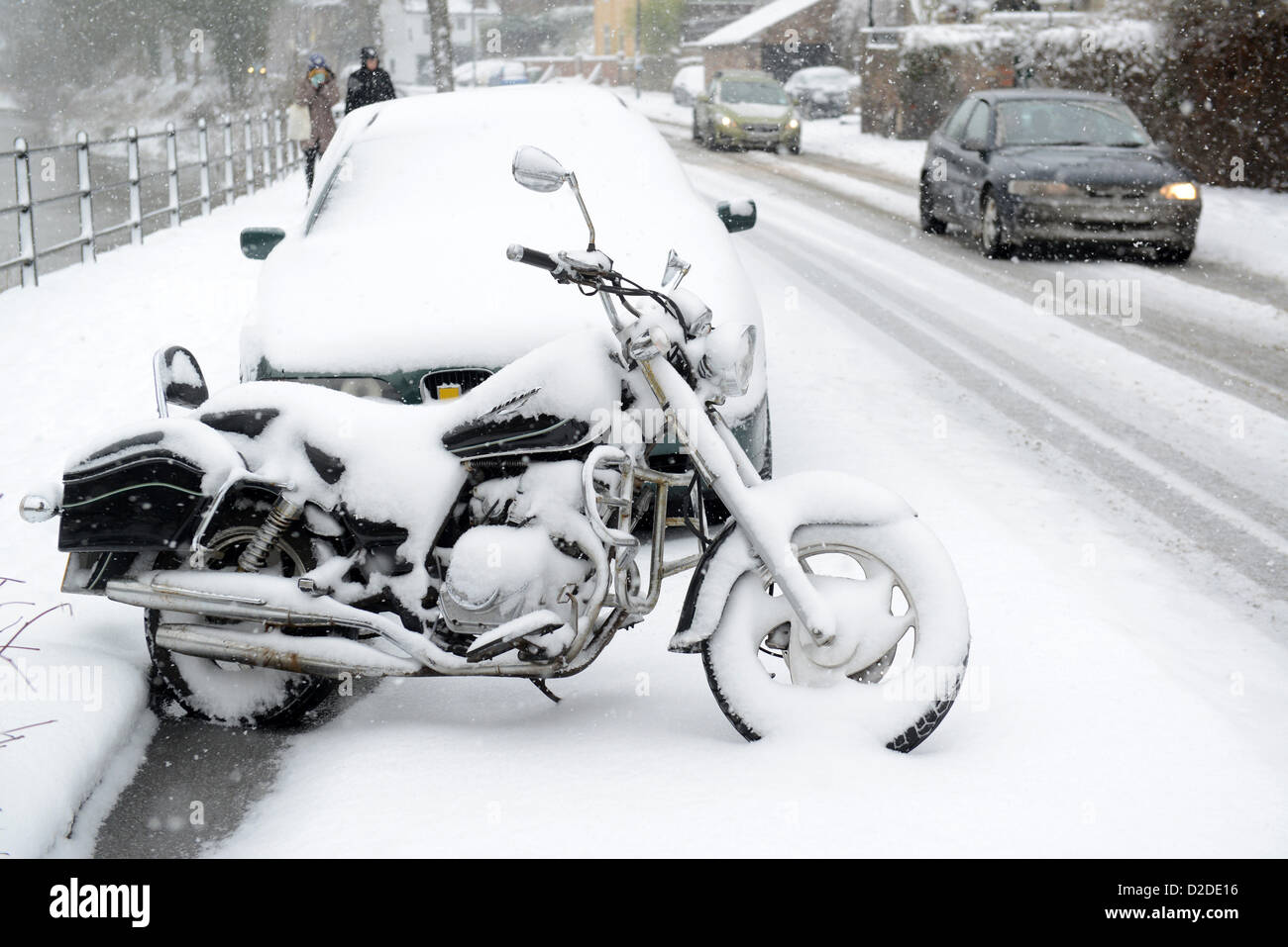 Motorbike covered in snow Uk. winter snowing roads road Britain weather conditions dangers dangerous transport driving British Stock Photo