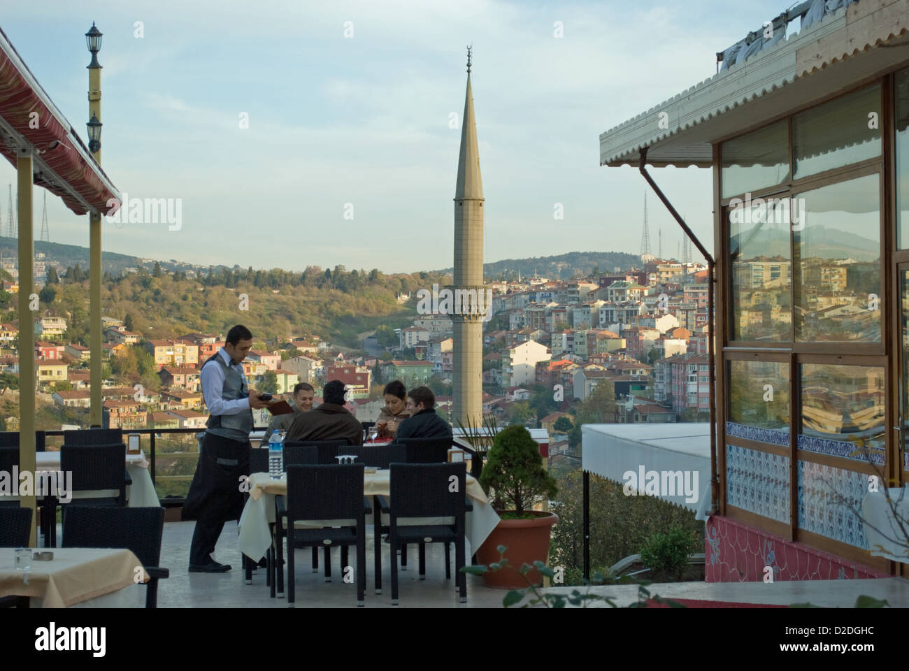 A waiter takes an order at hill top restaurant overlooking Kuzguncuk, in part of 'Old Istanbul'. Stock Photo