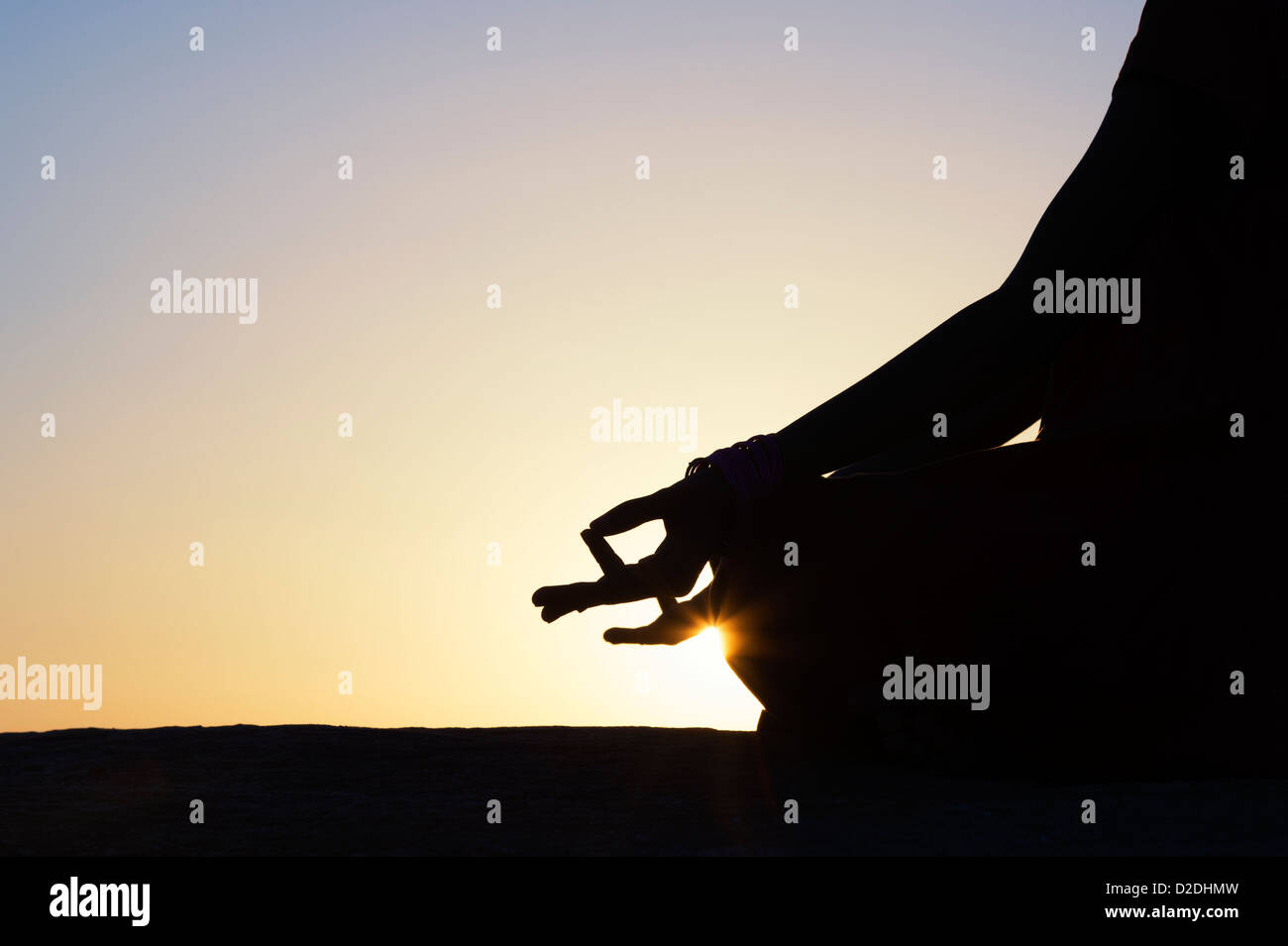 Sunset silhouette of an Indian girl meditating. Andhra Pradesh, India Stock Photo