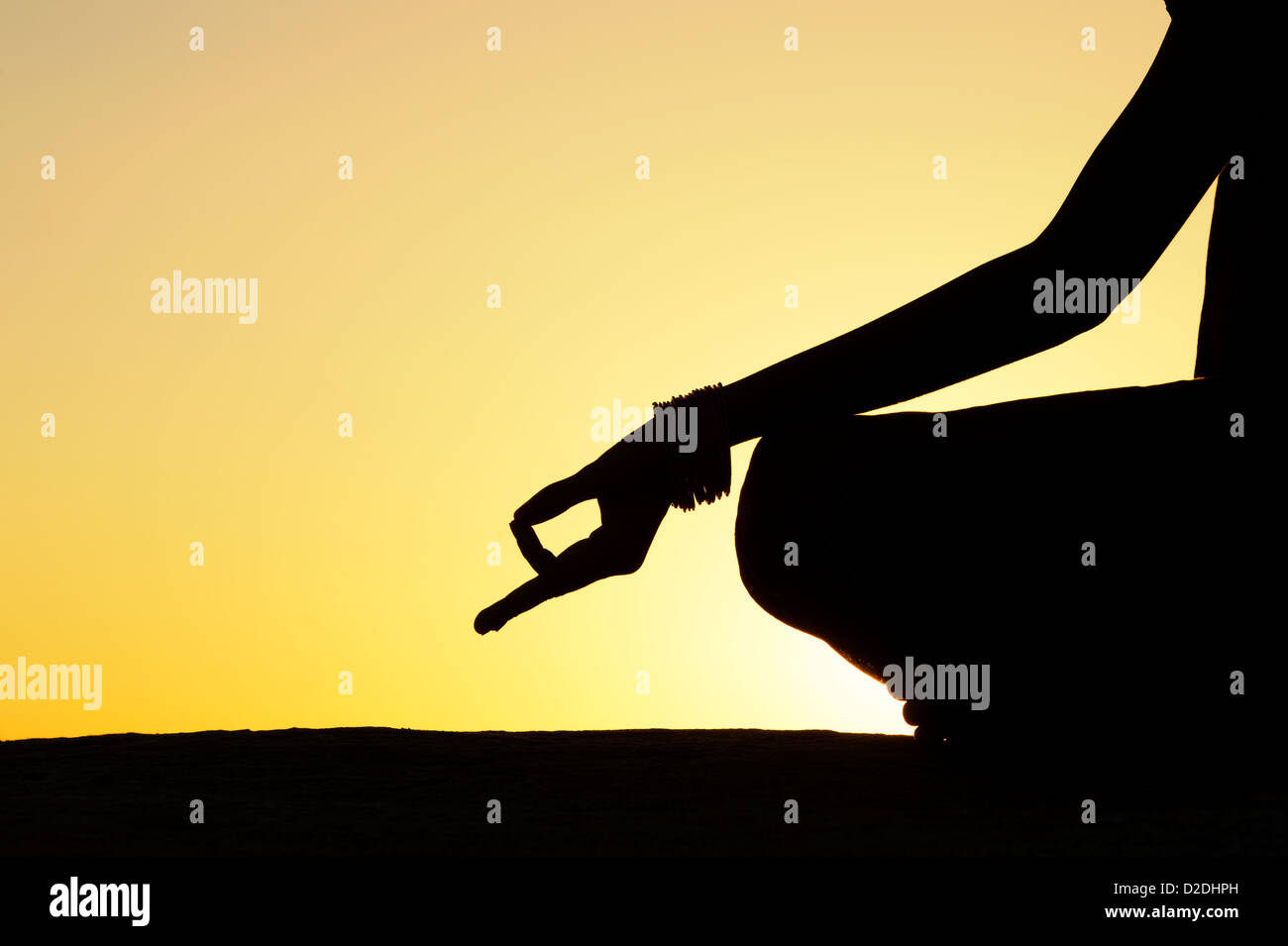 Sunset silhouette of an Indian girl meditating. Andhra Pradesh, India Stock Photo