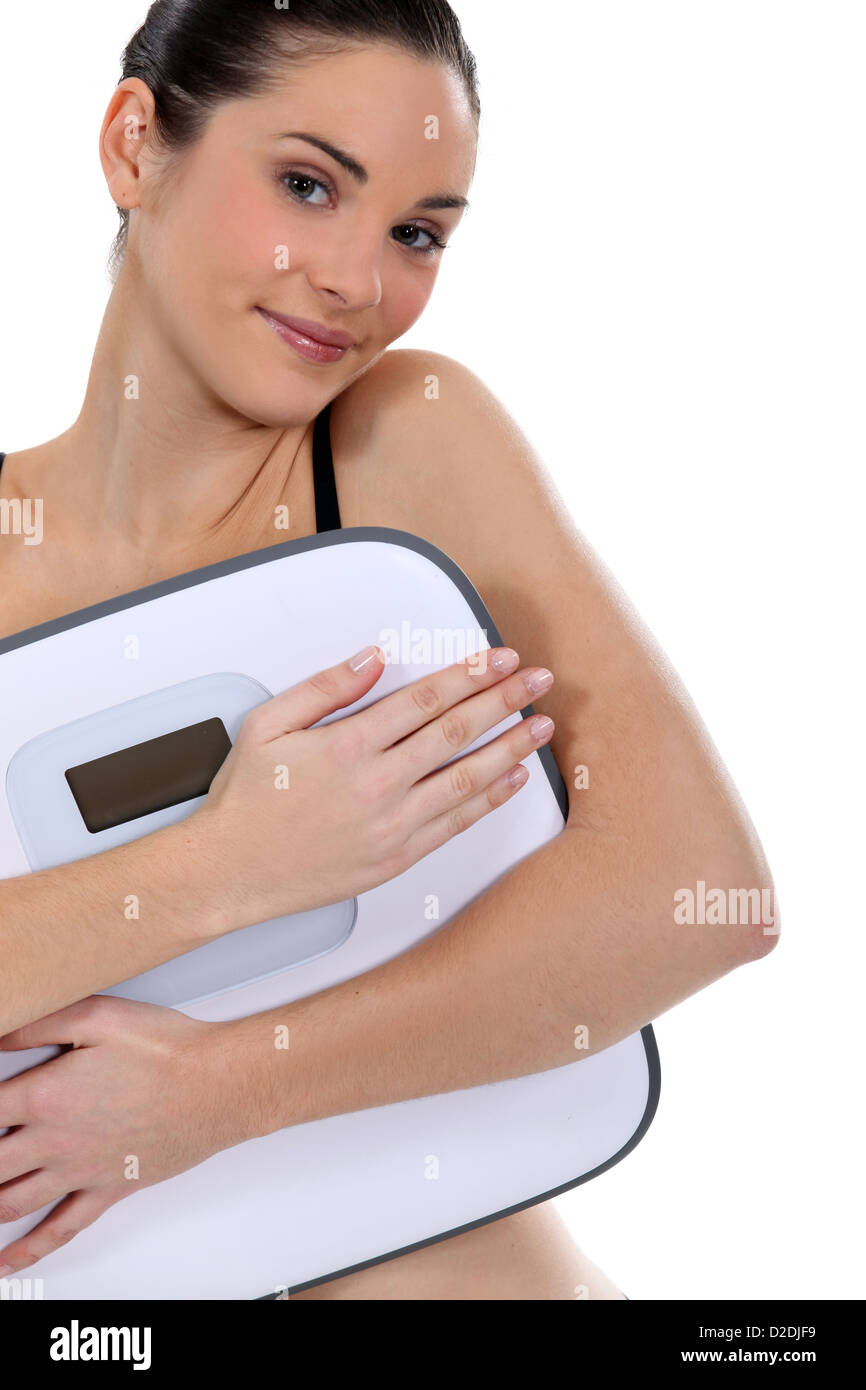Woman holding bathroom scales Stock Photo