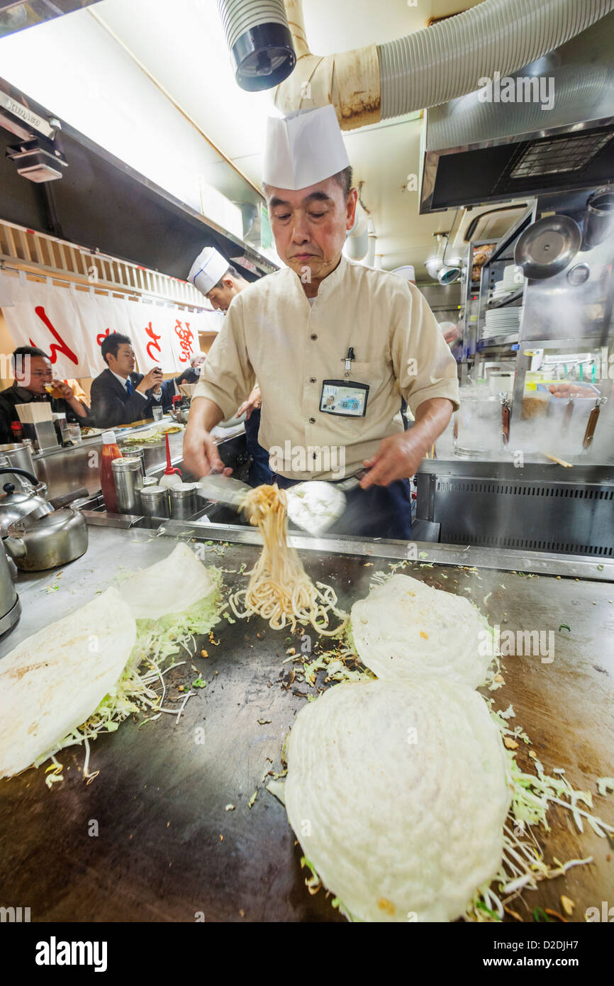 Japan, Kyushu, Hiroshima, Chef Cooking Okonomiyaki Stock Photo