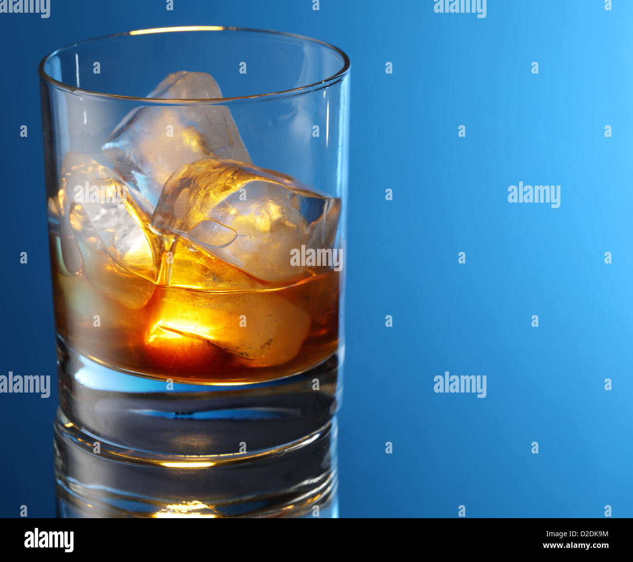 Whiskey glass on a blue background. Stock Photo