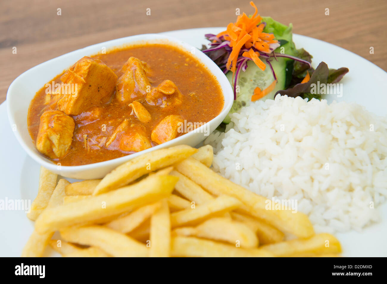 Chicken curry being served with rice, chips and salad Stock Photo Alamy