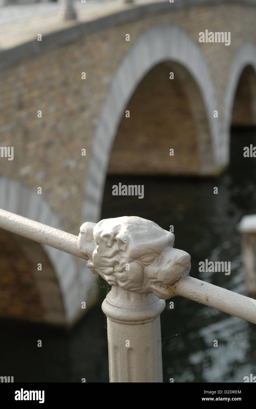 Canal Railing lion headed canal railing posts with canal bridge behind in bruges ...