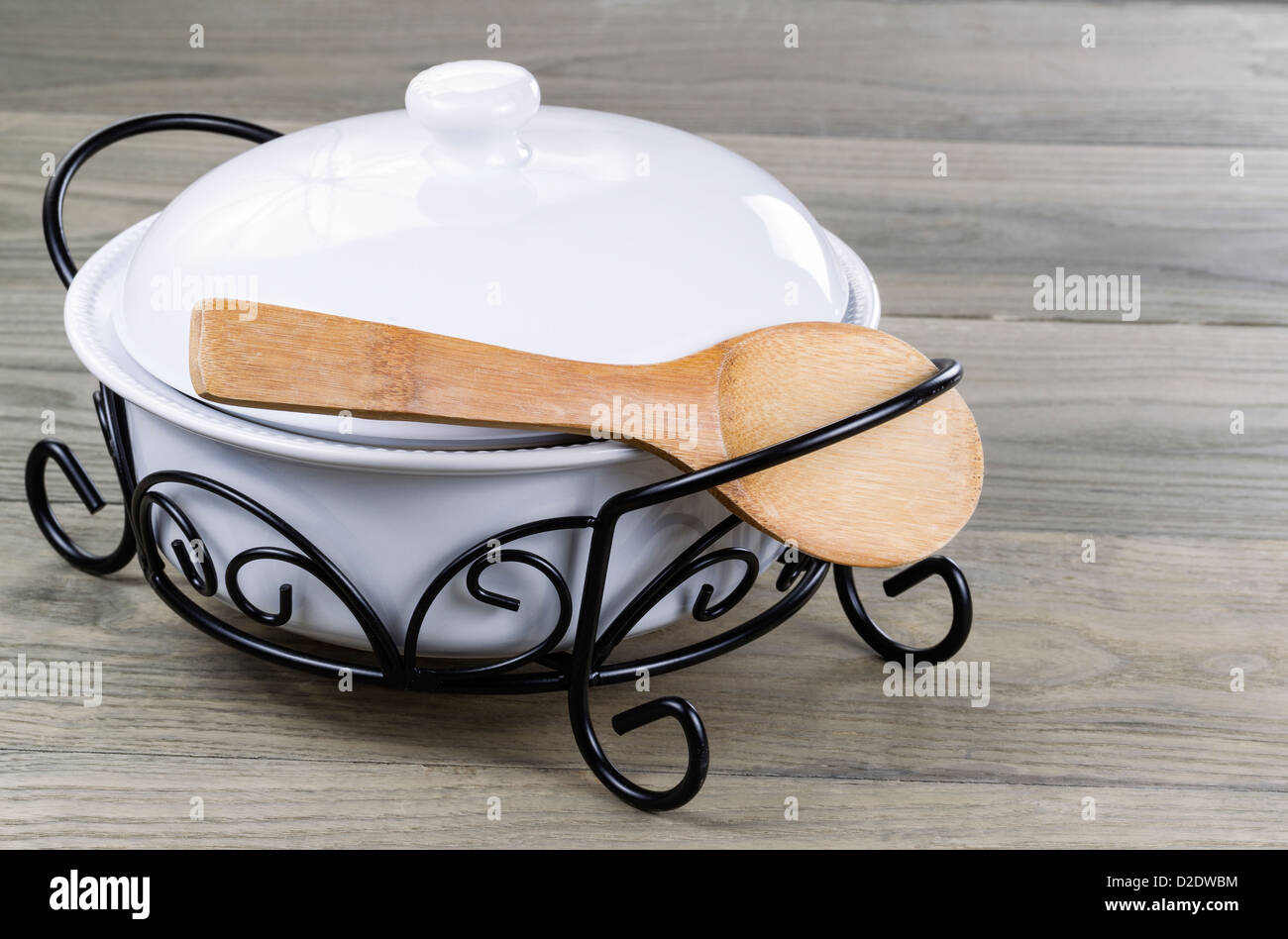 Traditional serving pot with wooden spoon on Stressed wooden table Stock Photo