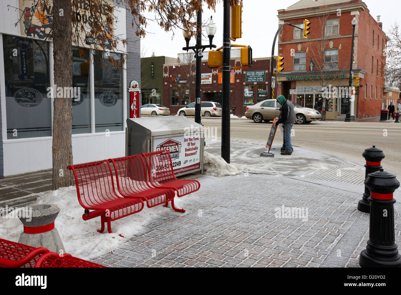 mans scraping snow and ice from sidewalk in saskatoon saskatchewan canada Stock Photo