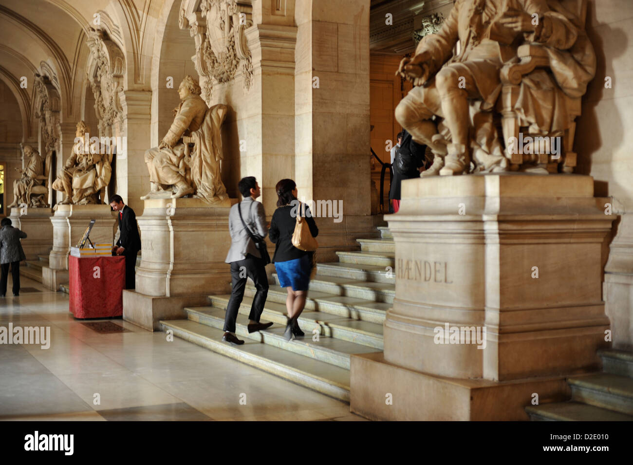 A couple of tourists walking up the steps inside the Paris Opera House Stock Photo