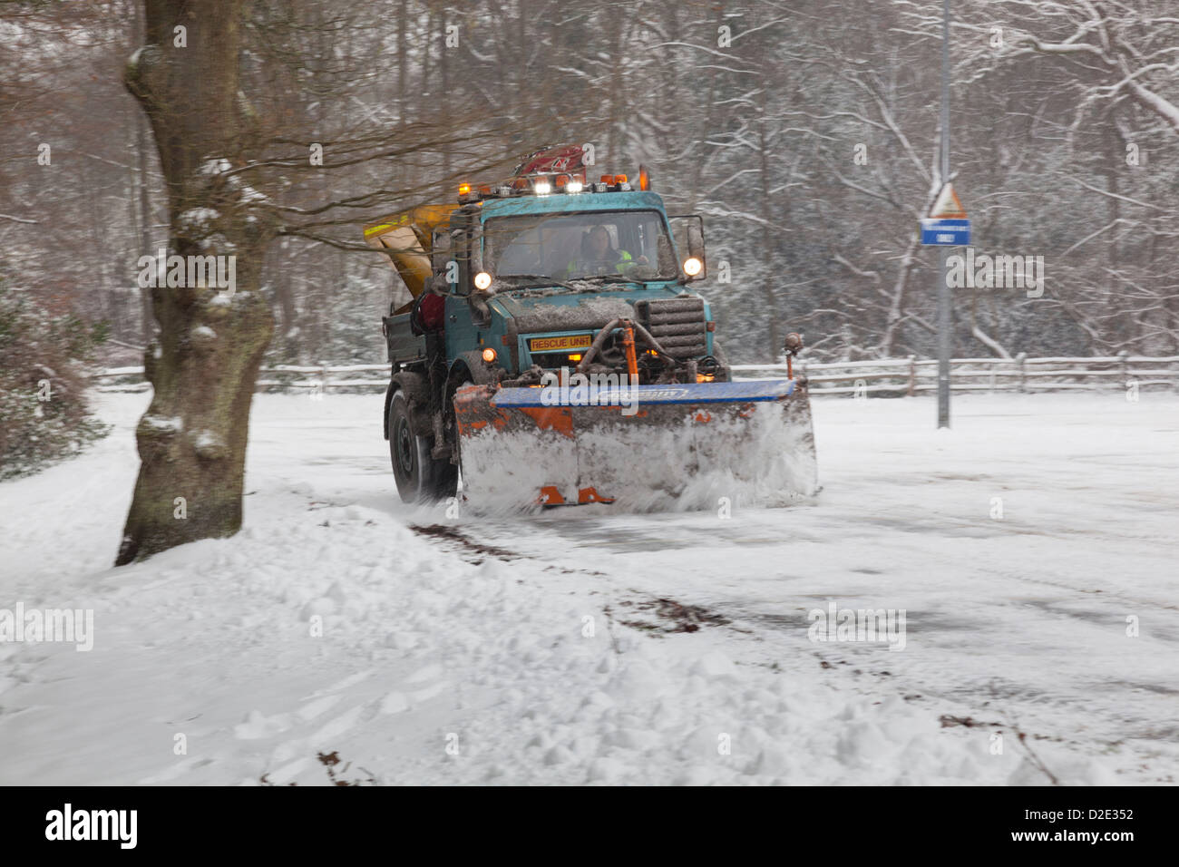 Snowplough and gritter lorry clearing snow from a country car park