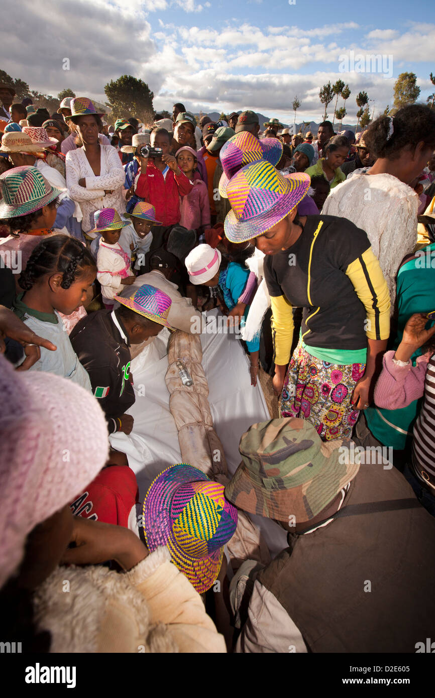 Madagascar, Betsileo famadihana ceremony, ‘turning of the bones’ family wrapping body in new lambamana burial shroud Stock Photo