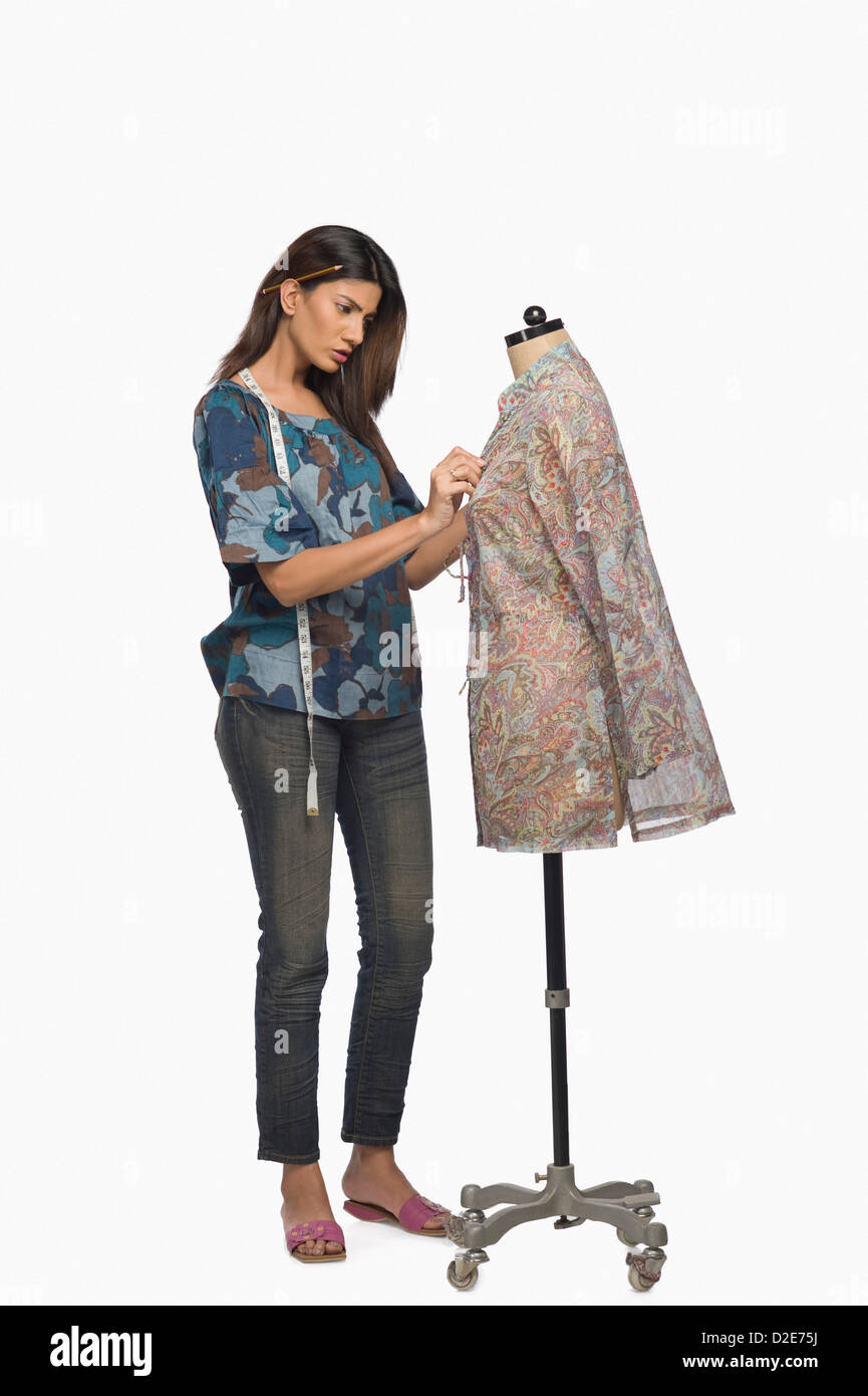 Female fashion designer trying a dress on a mannequin Stock Photo - Alamy