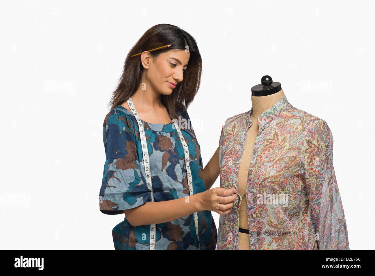 Female fashion designer trying a dress on a mannequin Stock Photo - Alamy