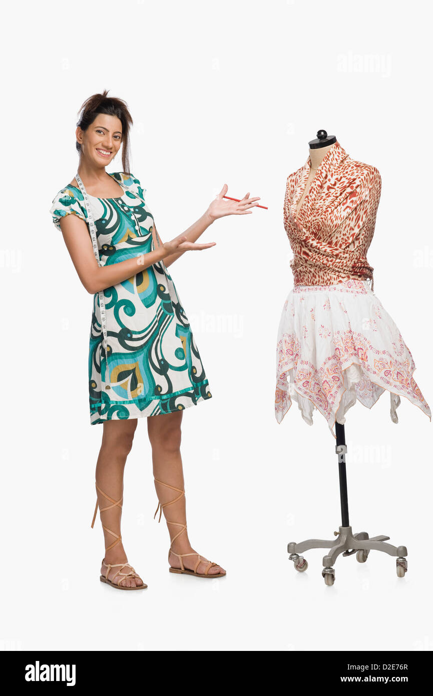 Female fashion designer showing a dress Stock Photo - Alamy