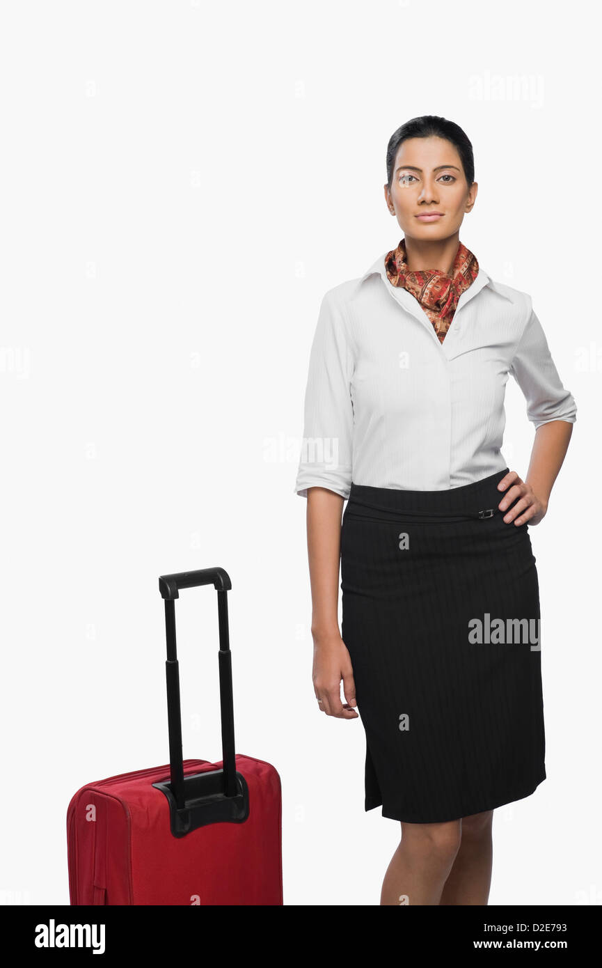 Portrait of an air hostess with her luggage Stock Photo