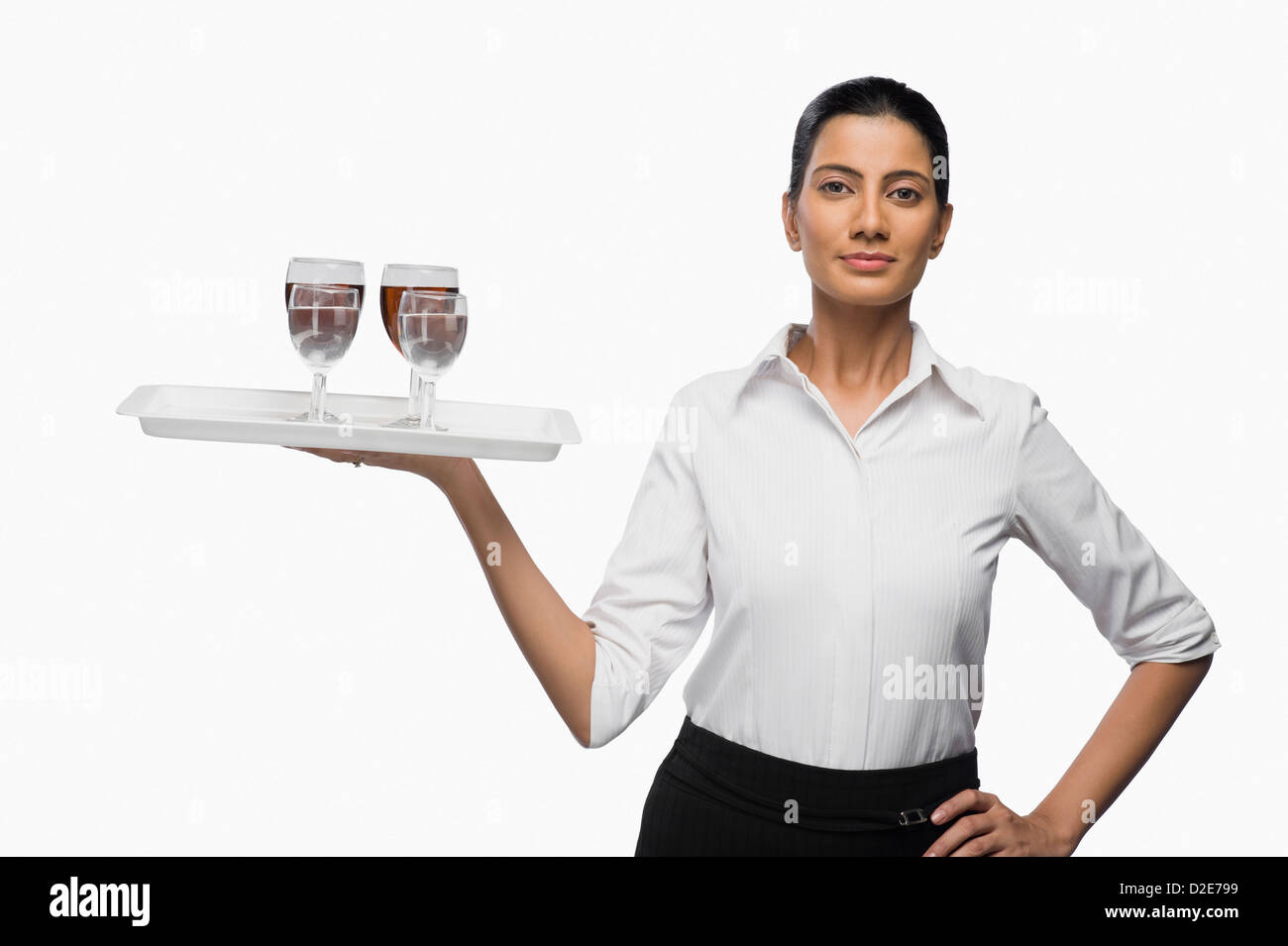 Air hostess carrying a tray of wine glasses Stock Photo