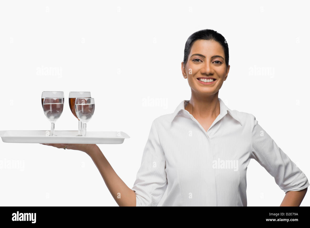 Air hostess carrying a tray of wine glasses Stock Photo