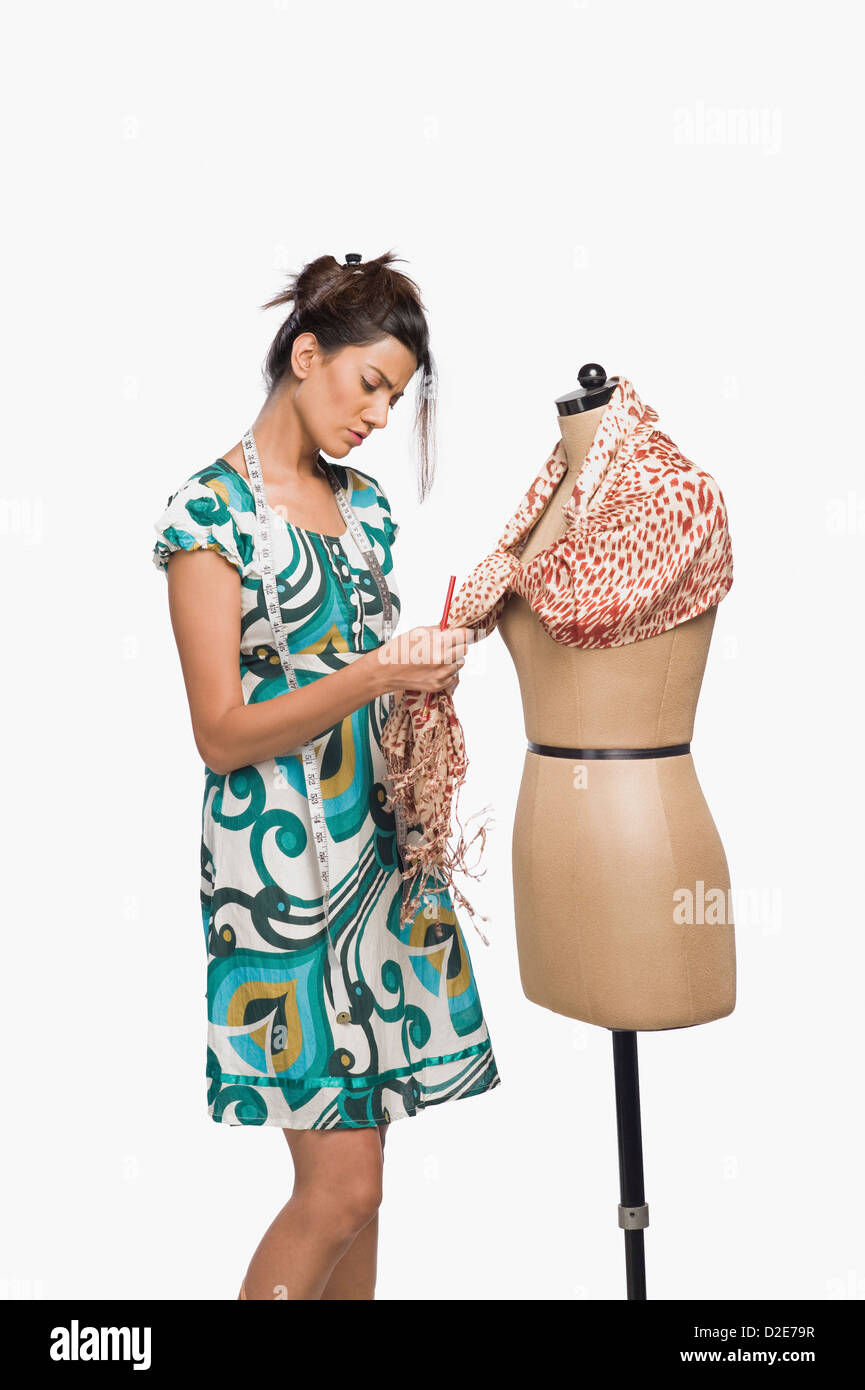 Female fashion designer trying a dress on a mannequin Stock Photo - Alamy