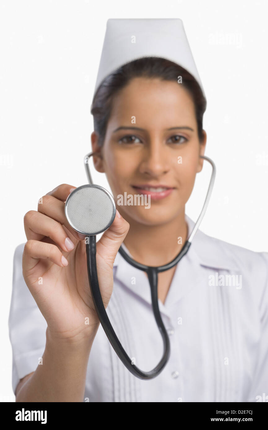 Female nurse holding a stethoscope and smiling Stock Photo - Alamy