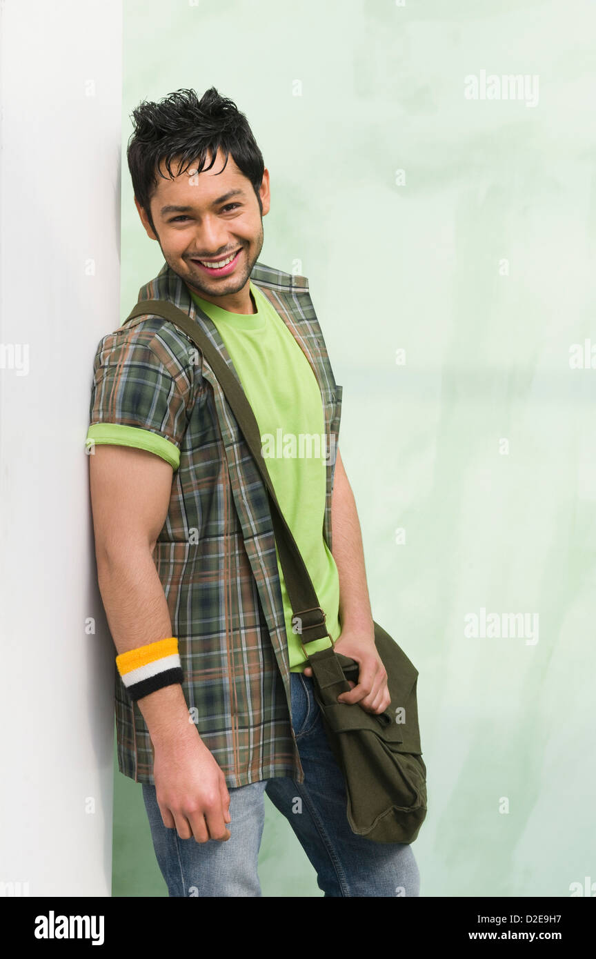 University student with a shoulder bag and smiling Stock Photo - Alamy