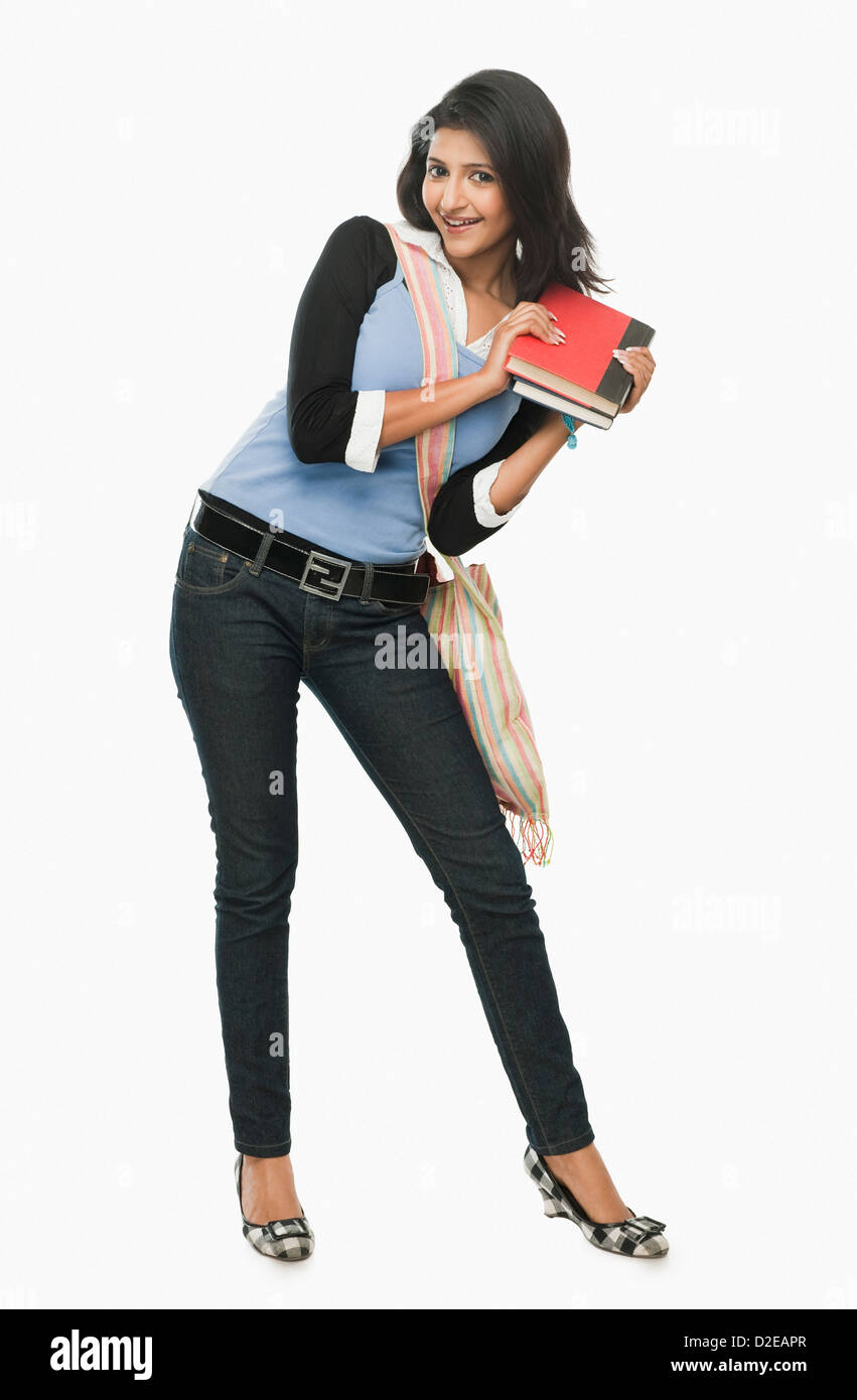 University student holding books and smiling Stock Photo - Alamy