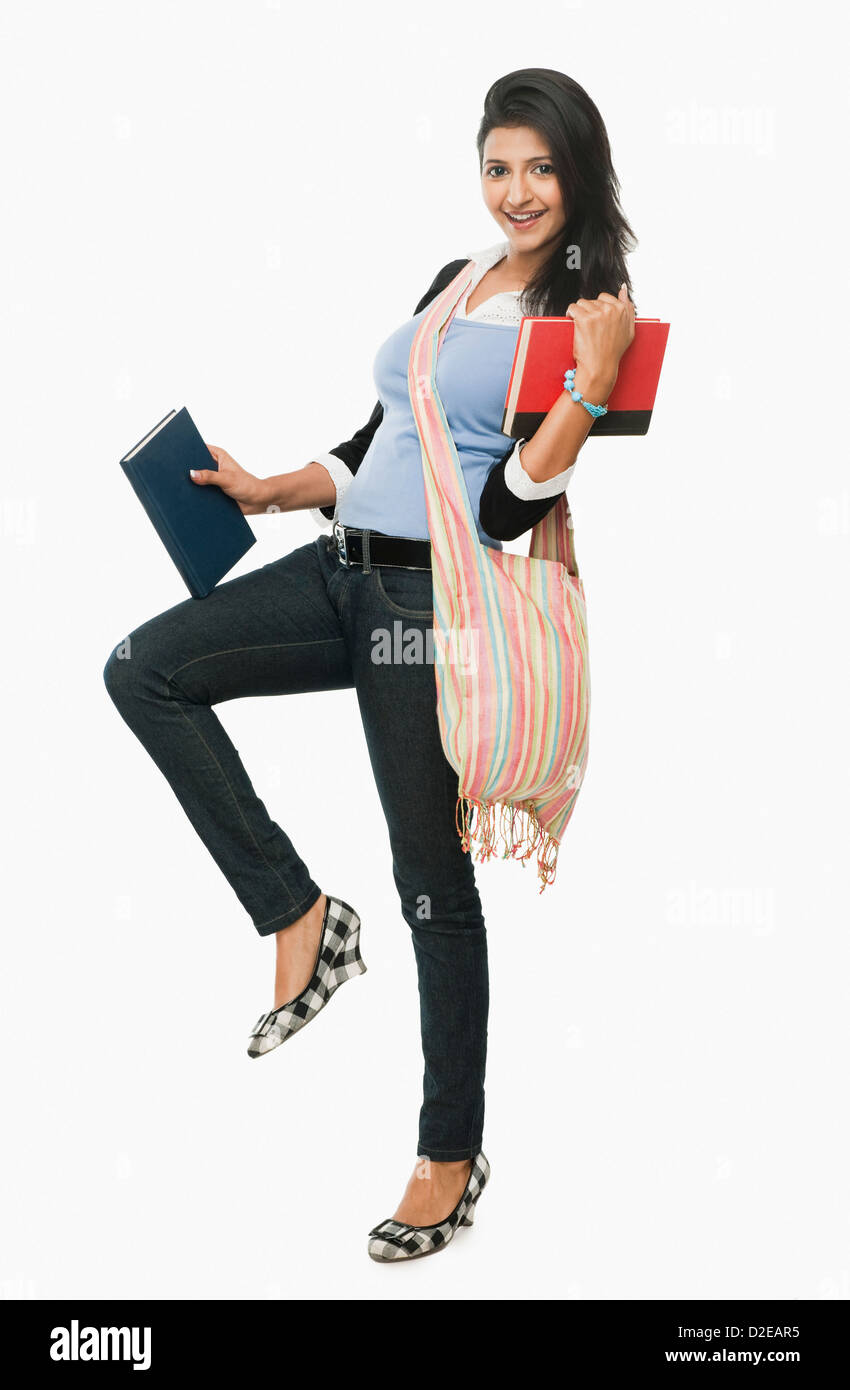 University student holding books and smiling Stock Photo - Alamy