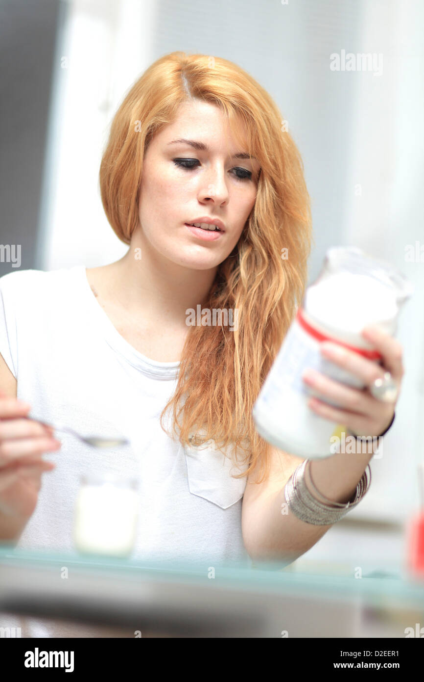 France, young woman eating yogurt Stock Photo Alamy
