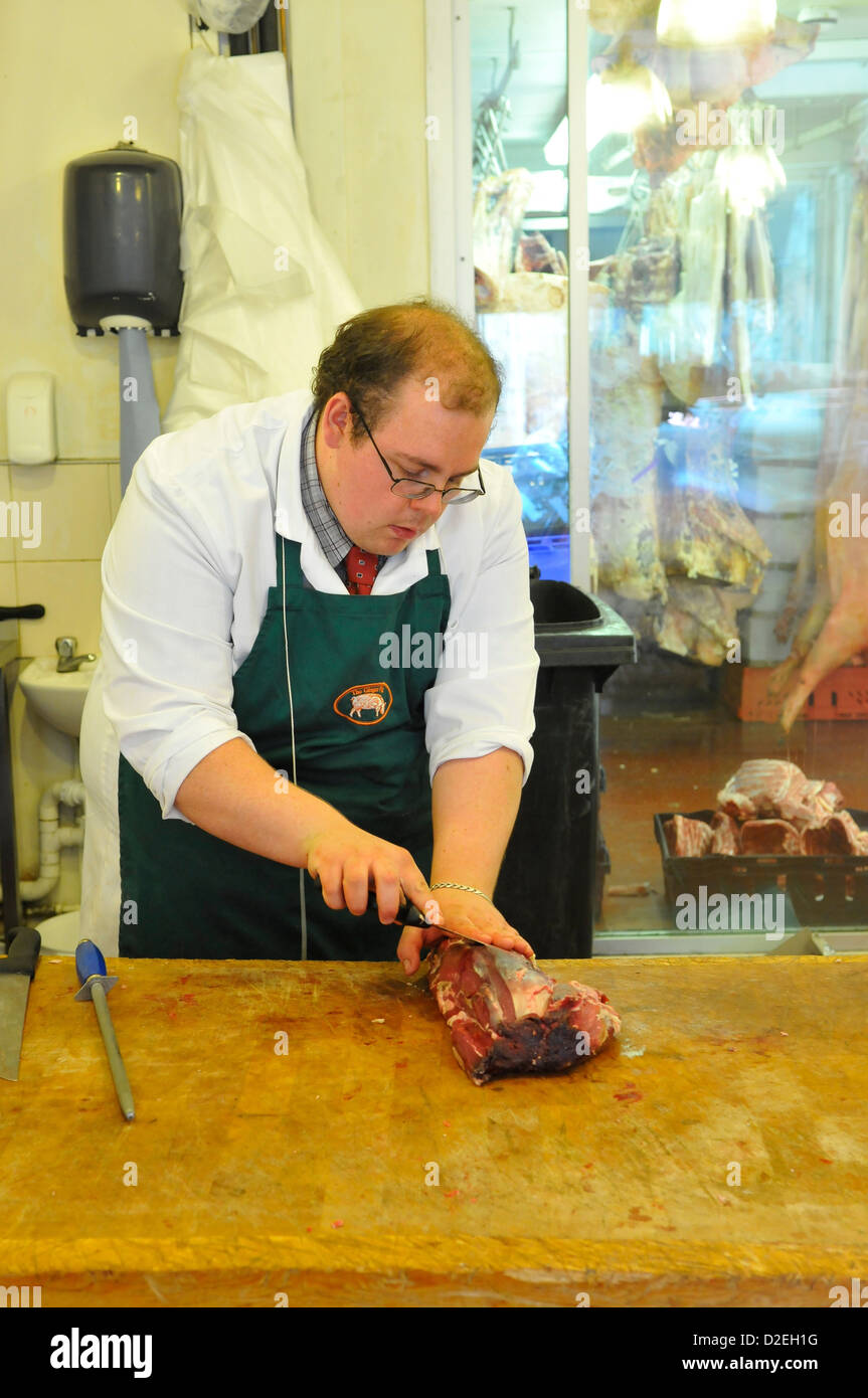 Butcher Cutting Meat at The Ginger Pig Butchers, Marylebone, London, England, UK Stock Photo