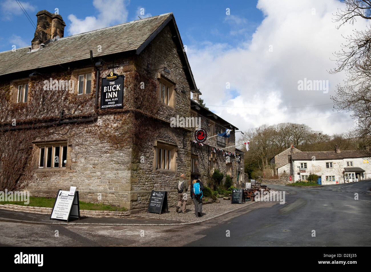 Walkers passing the 'The Buck Inn', Malham, Grassington, North Yorkshire Dales, UK Stock Photo