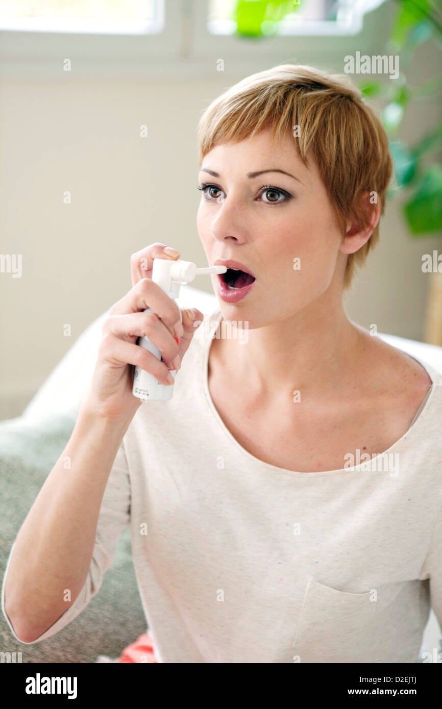 Using Mouth Spray WOMAN USING SPRAY IN MOUTH Stock Photo - Alamy