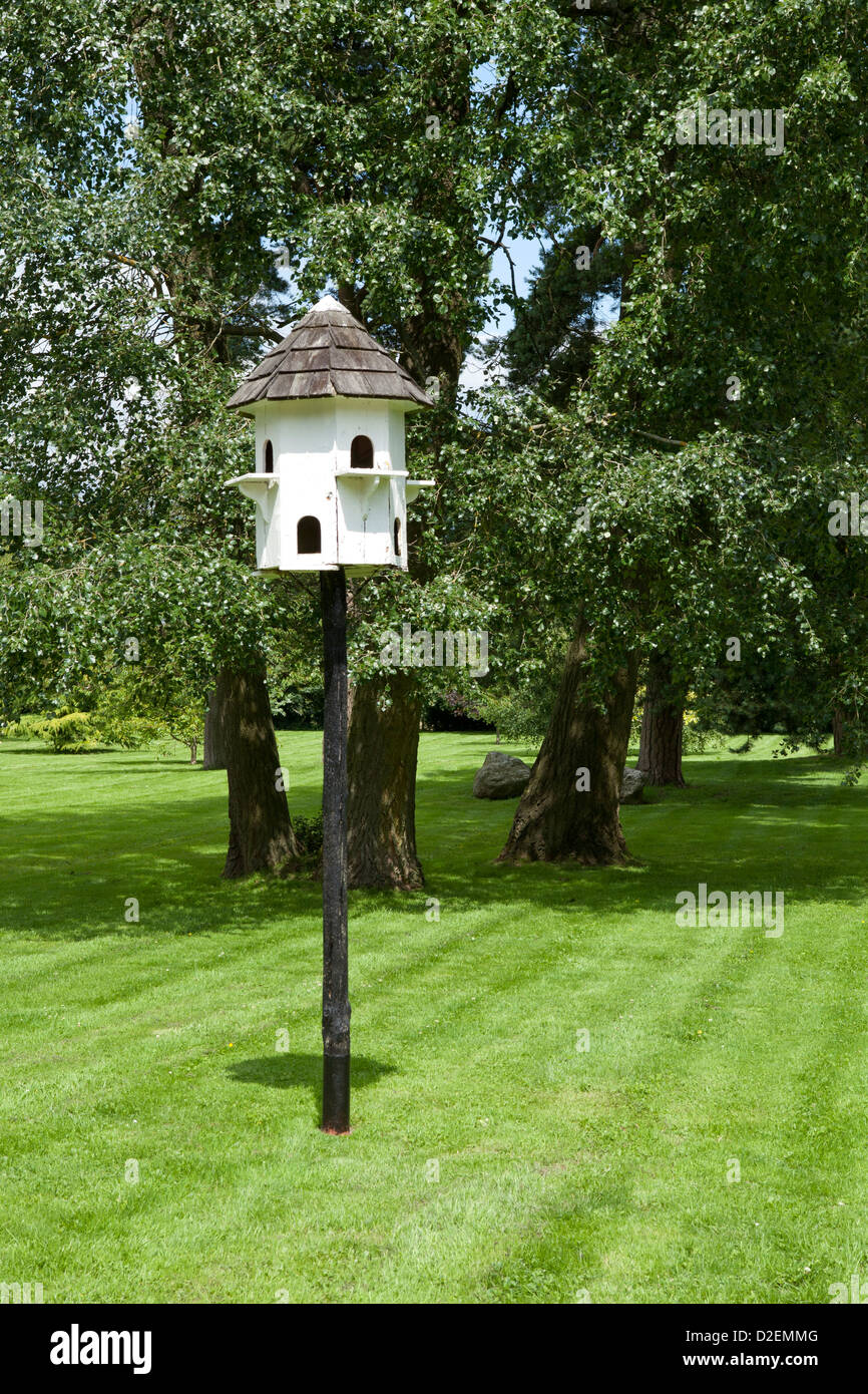 Freestanding dovecot in garden with trees Stock Photo