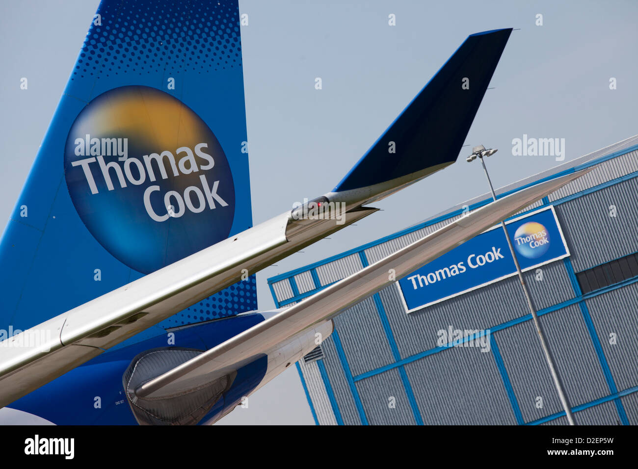 Airbus A330 Thomas Cook plane passing the Thomas Cook hanger at Manchester Airport Stock Photo