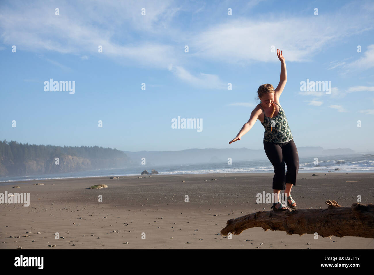 Young woman balancing on log near Third Beach in Olympic National Park, WA. Stock Photo